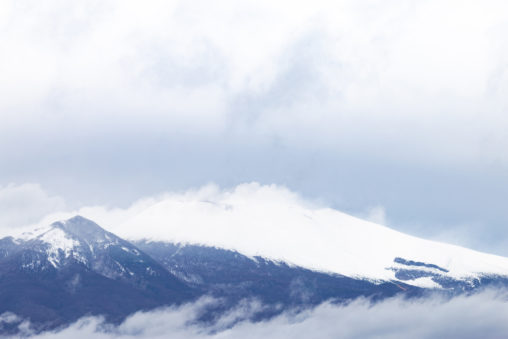雲と雪が積もった浅間山のフリー写真素材