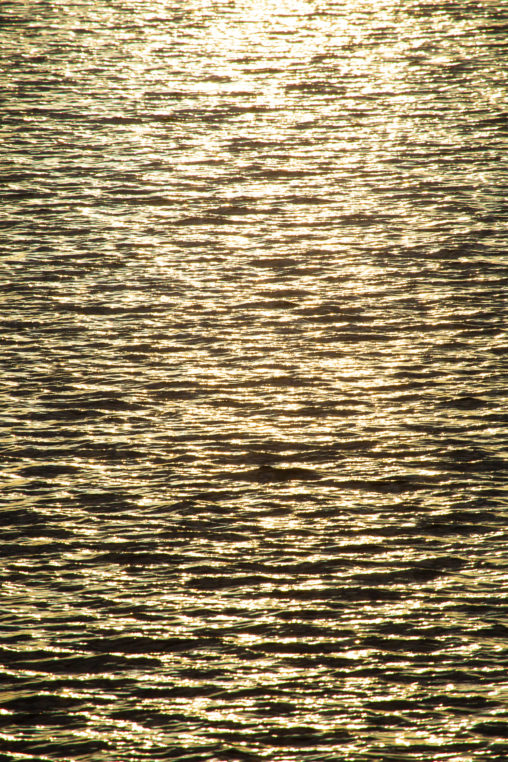 夕日に照らされた水面のフリー写真素材