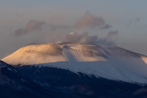 夕日に照らされる雪の浅間山（アップ）の写真