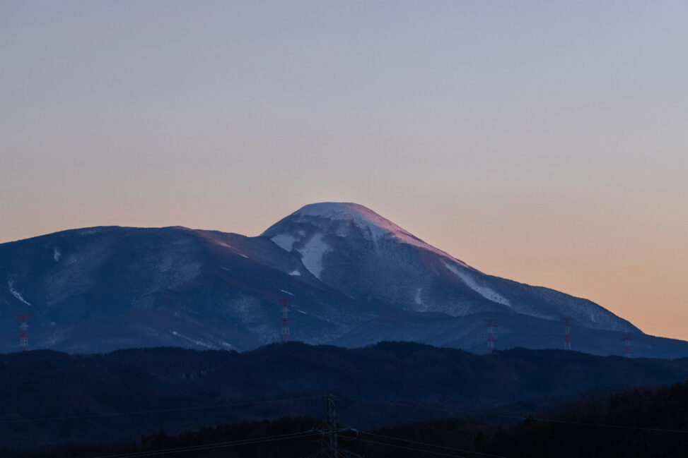 夕日に照らされる冬の蓼科山の写真